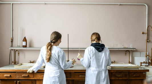 Two female lab workers standing for long hours, reflecting the need for posture tips.