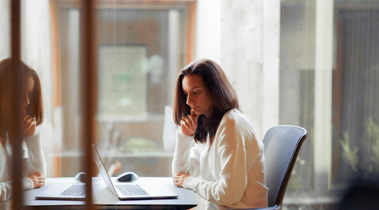 Woman sitting at desk with laptop, displaying sway back posture.