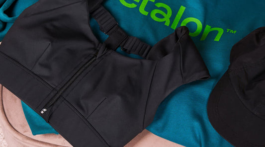 Etalon sweatshirt arranged in a flat lay with a posture bra and black cap to showcase a casual style.